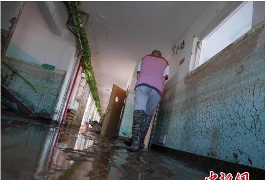 王丽英和同事不停地清淤，希望早日接回孩子。　苍雁 摄